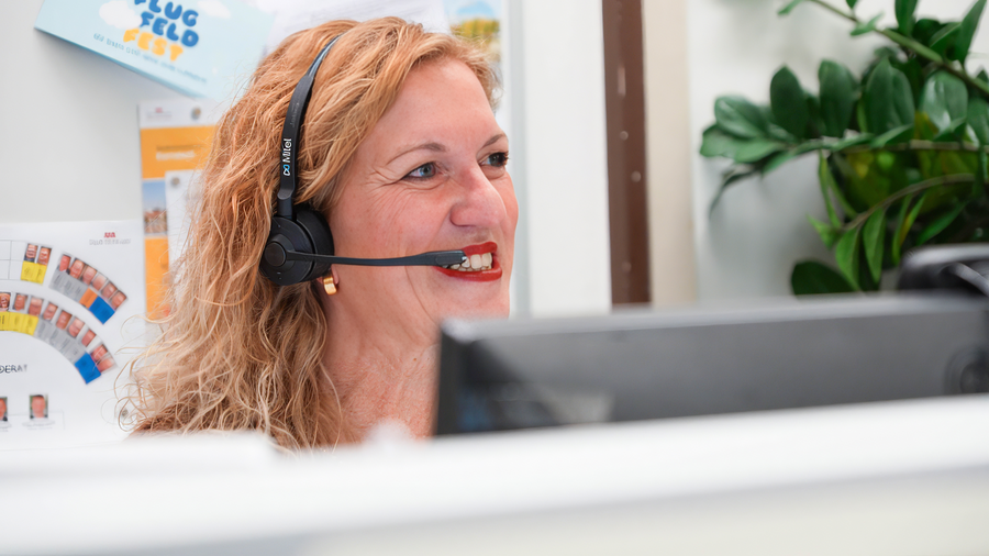 Lächelnde sympathisch wirkende Frau mit Kopfhörer und Mikrofon Lächelnde sympathisch wirkende Frau mit Kopfhörer und Mikrofon