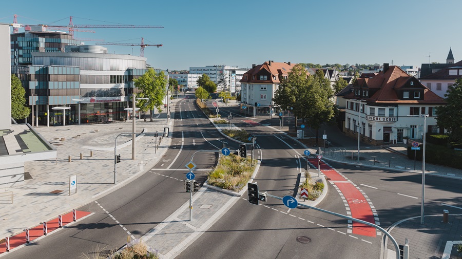 Klimaangepasste Umgestaltung der Kreuzung Herrenberger Str./ Poststraße Klimaangepasste Straßenkreuzung der Herrenberger Straße und Poststraße mit begrüntem Mittelstreifen, Trinkwasserbrunnen und Wasserfontänen.