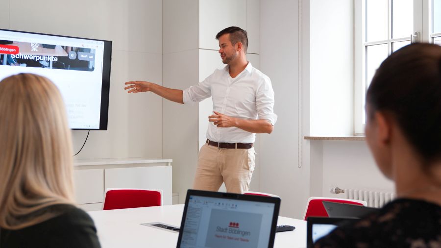 Mitarbeiter der Kämmerei, ein Mitarbeiter zeigt auf einen Bildschirm Mitarbeiter der Kämmerei, ein Mitarbeiter zeigt auf einen Bildschirm