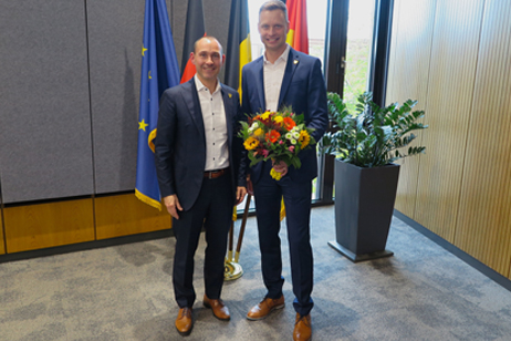 Oberbürgermeister und erster Bürgermeister mit Blumen ind er Hand
